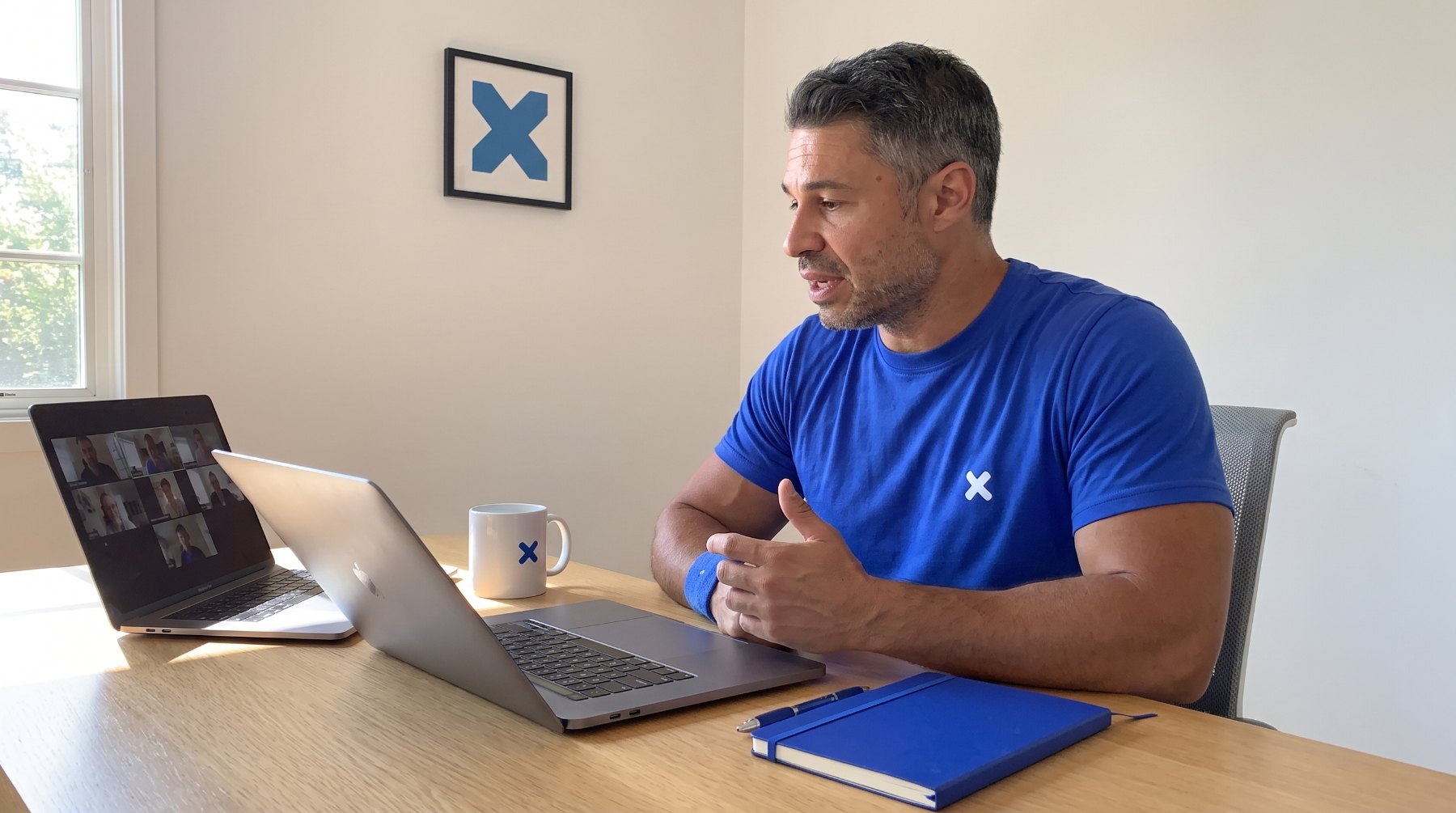 Daniel Mercer on a client video call at his desk in Austin, notebook open beside the laptop