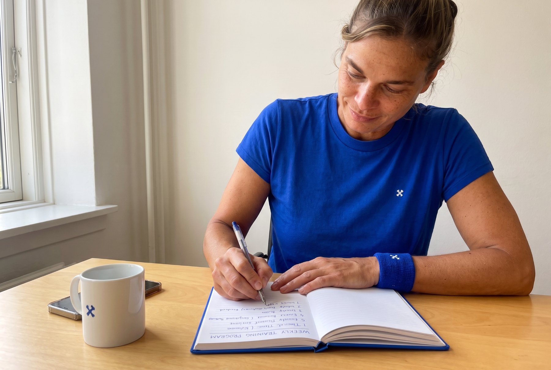 Claire writing next week's plan by hand before entering it in the app
